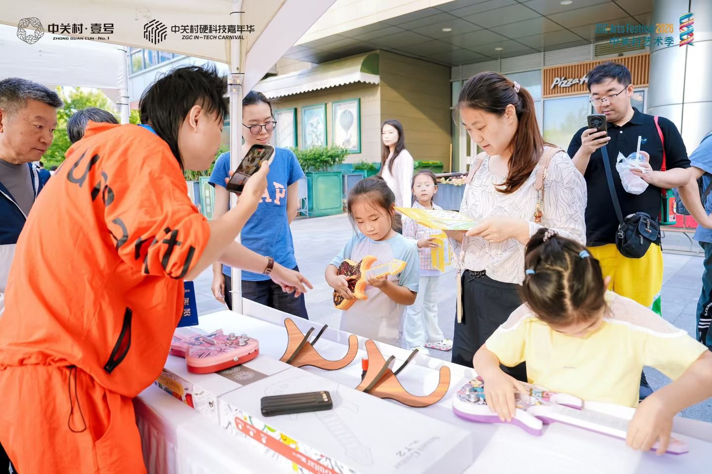 展台上摆放的儿童智能吉他与试玩的孩子